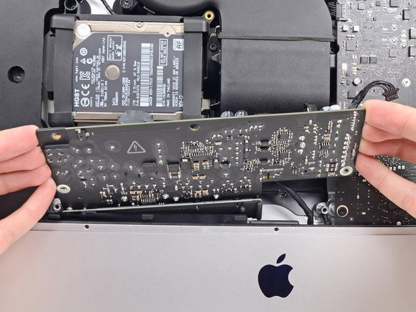 Image 2/3: '''Do not''' try to completely remove the power supply from the iMac yet—it is still connected to the logic board.