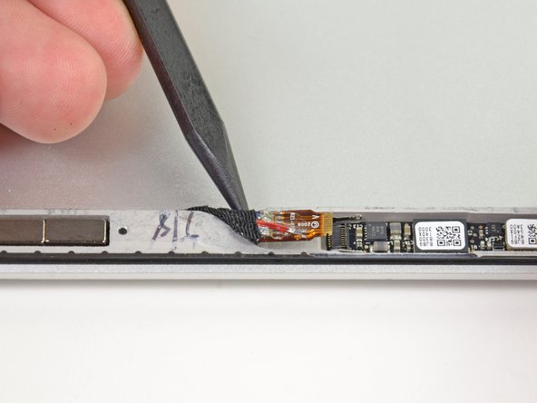 Image 2/2: Use the tip of a spudger to pull the iSight ribbon cable out of its socket.
