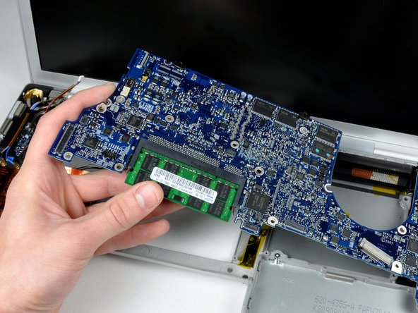 Image 2/2: Grasp the logic board at the left side and at the thin section, and rotate the logic board out of the lower case.