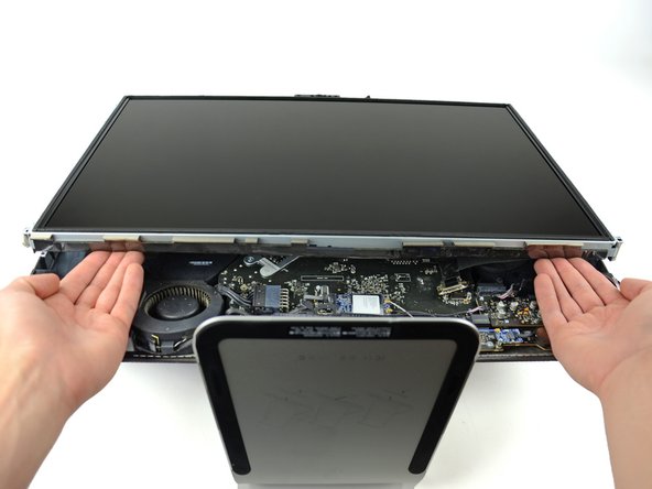 Place your hands on either side of the bottom of the display panel, and lift it up enough that you can reach the connectors inside.