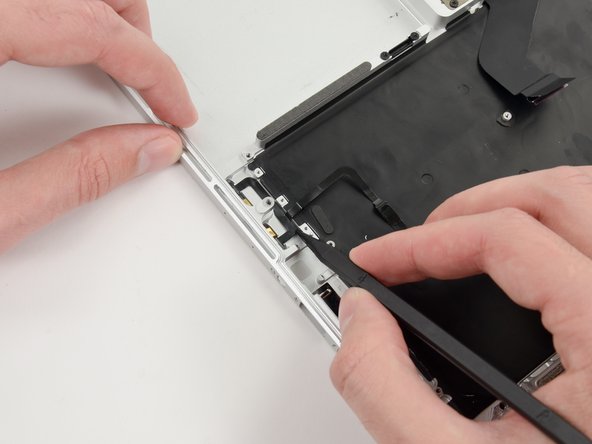 Image 1/3: Run the spudger up along the bottom of the microphone assembly cable to separate it from the upper case.