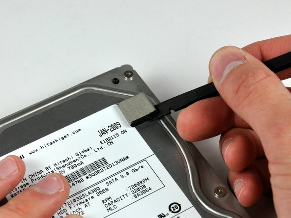 Use a spudger to remove the small piece of EMI foam from the top of the hard drive.