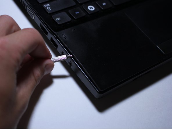There is a discrete little line between the two pieces of plastic on the side of the keyboard.