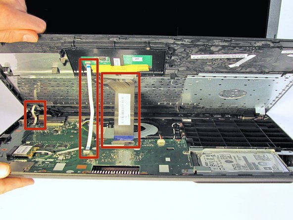 Locate the three ribbons connecting the keyboard plate cover to the bottom cover.