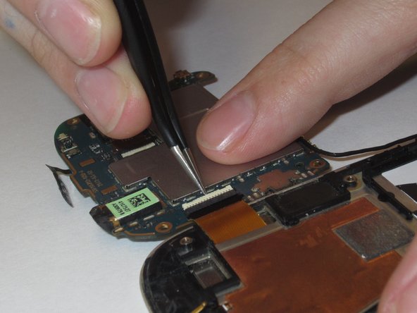 Remove the gold ribbon cable by lifting tab at the back of the socket, using a spudger or tweezers.