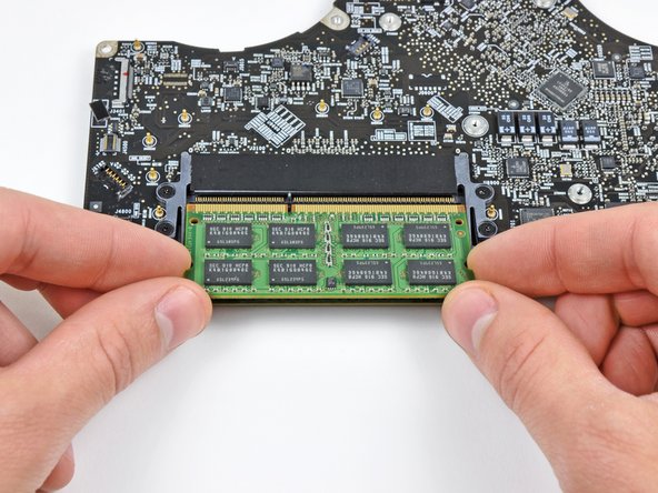 Image 2/2: After the RAM chip has popped up, pull it straight out of its socket.