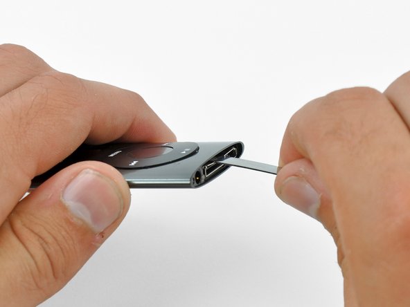 Image 2/2: Use the metal spudger to pry up the bottom edge of the click wheel.