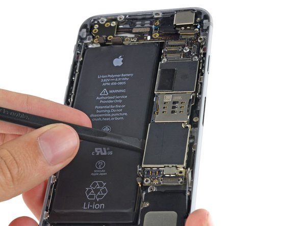 Image 2/2: Insert the spudger near the metal shields below the SIM card tray to avoid damaging any chips or sockets.