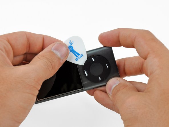 Image 2/2: Do not try to completely remove the click wheel yet, as it is still held in place by a ribbon cable.