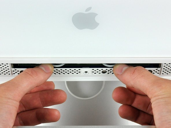 Image 2/2: Use your thumbs to press both RAM arms in past the front bezel for enough clearance to lift it off the rear case.