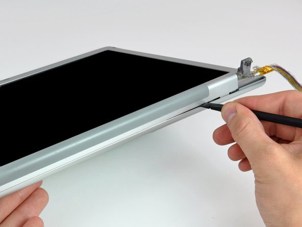 Image 1/2: Twist the spudger to separate the lower edge of the rear display bezel from the clutch cover.