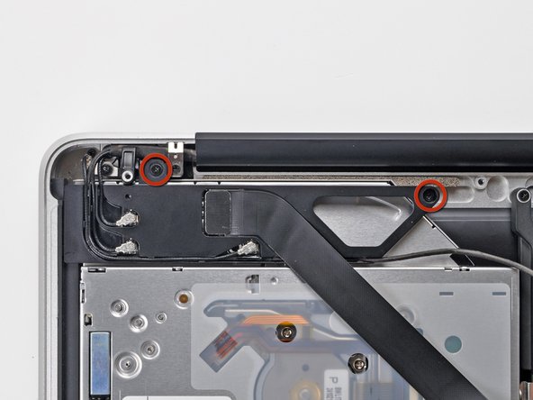 Image 1/2: Carefully rotate the AirPort/Bluetooth board housing (with AirPort/Antenna cables still attached) out of the lower case.