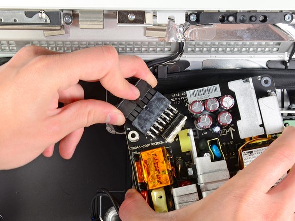 Image 2/2: Once the locking mechanism has cleared the socket, pull the DC-in connector away from the power supply.