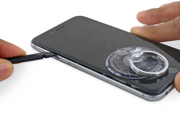 Slide the spudger up the side of the phone to separate the adhesive and pop the clips free.