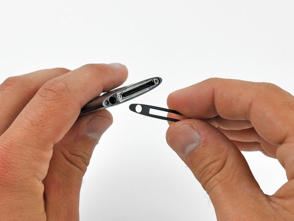 Image 2/2: Use a plastic opening tool to pry the bezel from the case of the iPod and remove it.