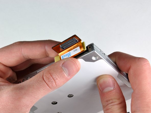 Image 2/2: Rotate the drive and disconnect the orange ribbon cable from the optical drive.