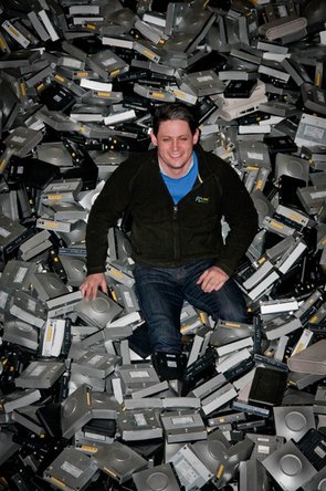 Man on pile of e-waste at a recycling facility