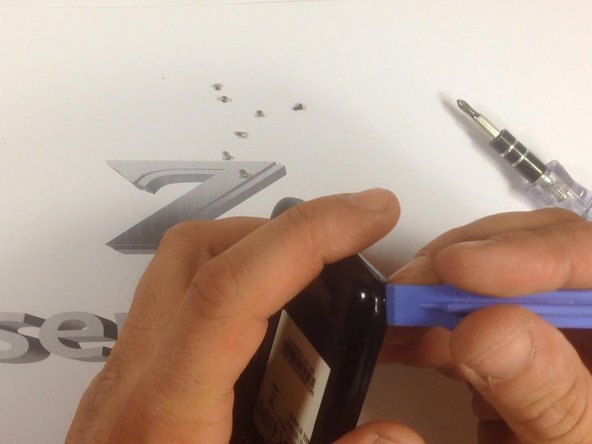 Use a plastic tool to remove the rear housing.