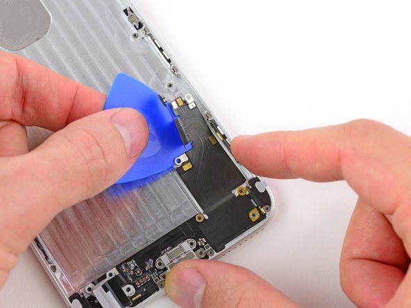 Image 2/3: Carefully work the pick down the right side of the Lightning connector and headphone jack cable, making sure to '''stop''' right as you hit the bottom.