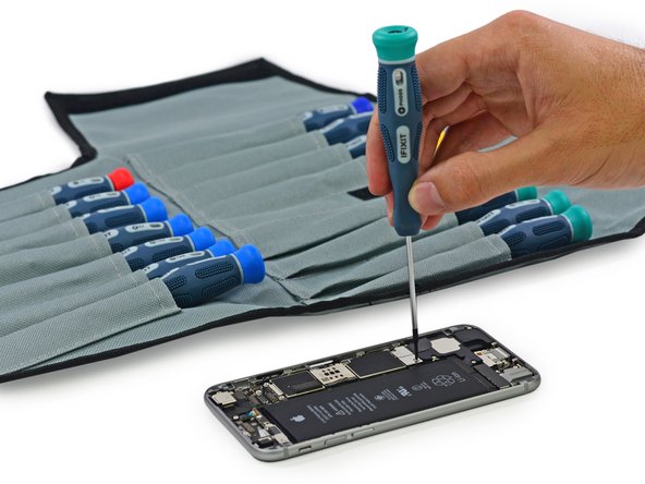 Image 2/2: With screwdriver in hand, we tackle the metal bracket screws that secure the front panel assembly in place.