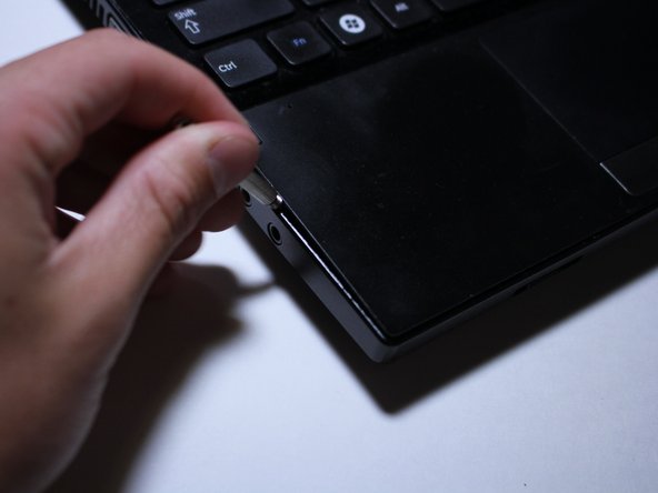 Use the flat head of your screwdriver to pry apart the two pieces of plastic.