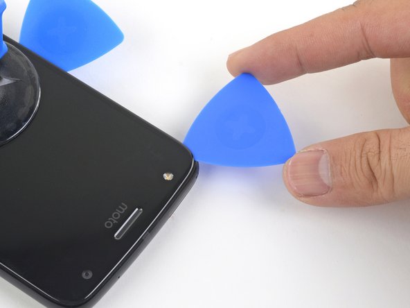 Carefully slice around the corner and through the top edge to separate the adhesive.