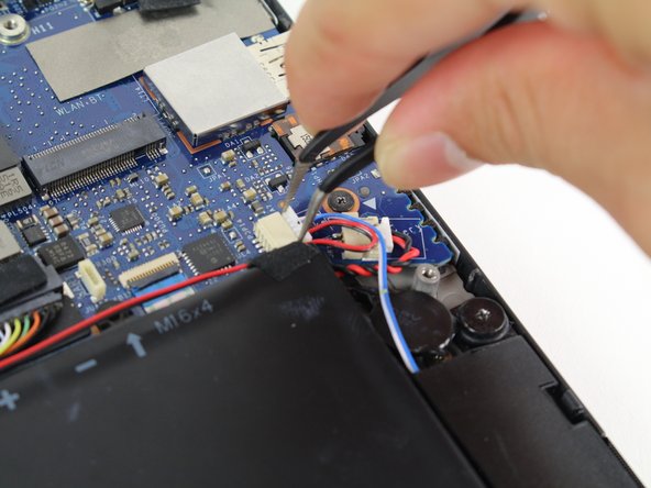 Use tweezers to remove the white connector from its socket by pulling it to the right.