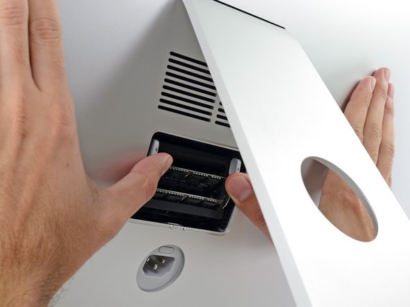 Image 1/3: Use your thumbs or index fingers to unlock the tray by pushing the tabs outward, away from the RAM.