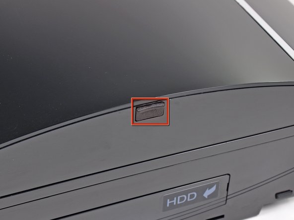 Use the tip of a spudger to remove the black rubber screw cover from the side of the PS3.