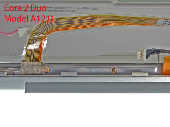 Image 2/2: If you have a Core 2 Duo Model A1211 machine, refer to picture 2 and remove two Phillips screws connecting the clutch assembly to the lower edge of the front display bezel near the display data cable.