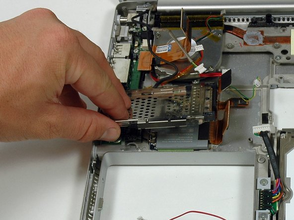 Image 1/1: When replacing the PC card cage, make sure you attach it to the post on the metal eject button.