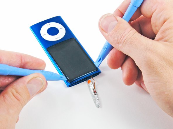 Image 1/2: Slide the second iPod opening tool toward the bottom of the device to remove the adhesive.