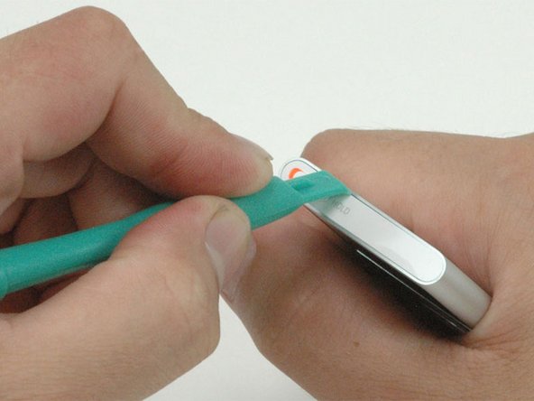 Carefully insert an iPod opening tool in the seam between the metal casing and white plastic top.