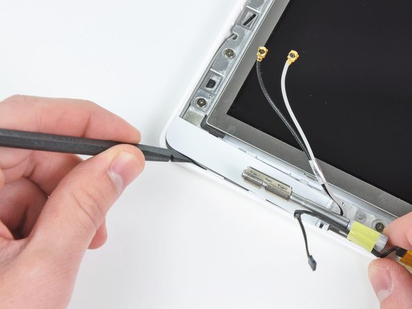 Use a spudger to slide the left bezel cover towards the LCD panel.