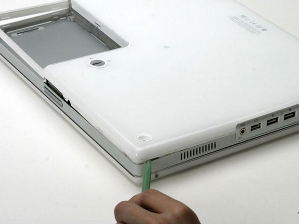 Image 1/1: There are two tabs on the port side of the computer, one near the front corner and one near the sound out port.