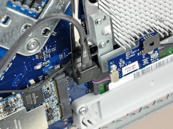 Image 1/2: The SATA connector on most iMacs tends to stick in its socket on the logic board. If you are having trouble disconnecting the SATA cable, insert a [product|IF145-012|metal spudger] or any other thin tool into the gap between the SATA connector and its socket and twist the spudger's shaft to safely separate the two pieces.