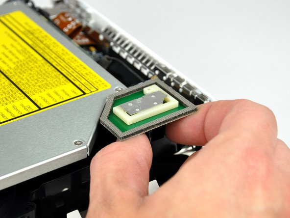 Image 2/3: Slightly squeeze the two retaining arms toward each other and lift the AirPort antenna off its post.