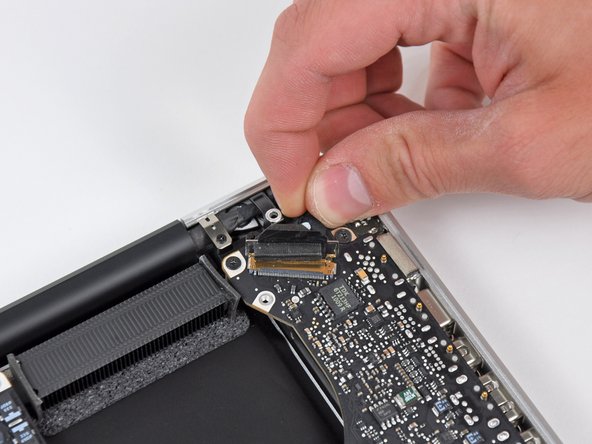 Image 3/3: Do not pull the cable upward, as the socket is very fragile. Pull the cable parallel to the face of the logic board toward the corner of the upper case.
