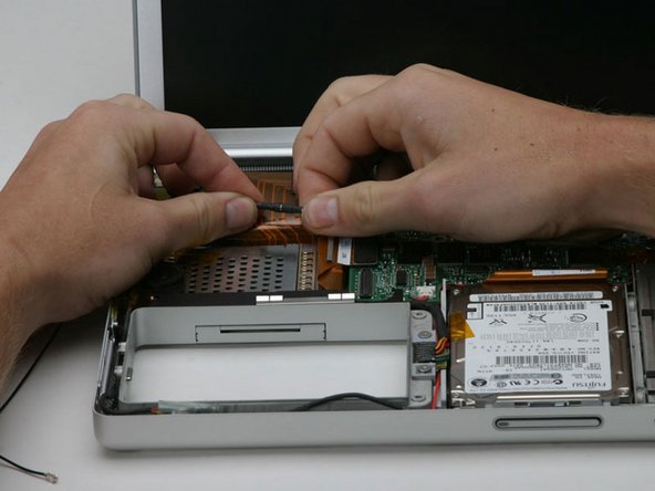 Image 1/1: Disconnect the Airport antenna cable at the black connector, making sure you pull only on the black rubber portion of the connector.