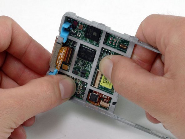 Image 1/1: The logic board is secured to the framework with mild adhesive. Be careful not to bend the logic board by pushing too much in any one spot.