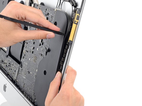 Image 2/3: Run the spudger down along the right side of the speaker to pry the antenna cable from its channel in the right speaker.