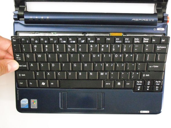 Lift top of keyboard up. If it doesn't lift easily, there may be tabs on the sides - use the tool to ease them aside and/or shift the keyboard from side to side.