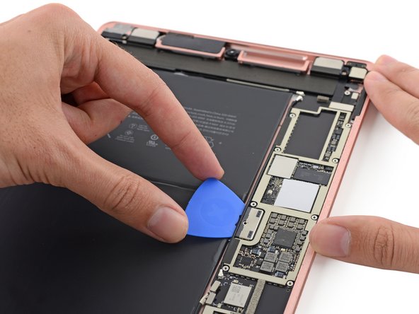 Image 2/3: Our fingers are itching for chips, but for now we restrain ourselves and settle for isolating the battery. One precisely-placed [https://www.ifixit.com/Store/Parts/Battery-Isolation-Pick/IF145-304-1|pick|new_window=true] separates the battery contacts from the logic board.