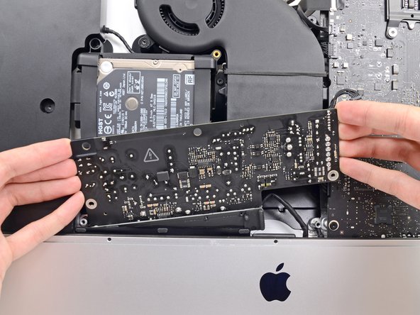 Image 1/3: '''Do not''' try to completely remove the power supply from the iMac yet—it is still connected to the logic board.