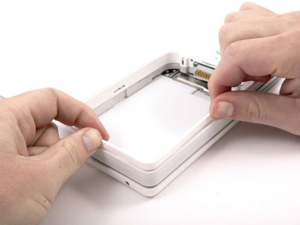 Image 1/1: Push the thin rims of the lower case surrounding the battery compartment in, bending them past the tabs, and then lift up to free that corner of the lower case.