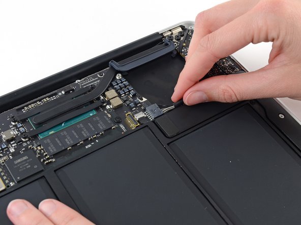 Image 1/1: Pull the cable parallel to the face of the logic board toward the right edge of the Air.