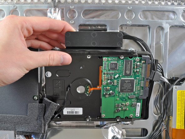 Image 2/2: Pull the top edge of the hard drive slightly away from the rear case.