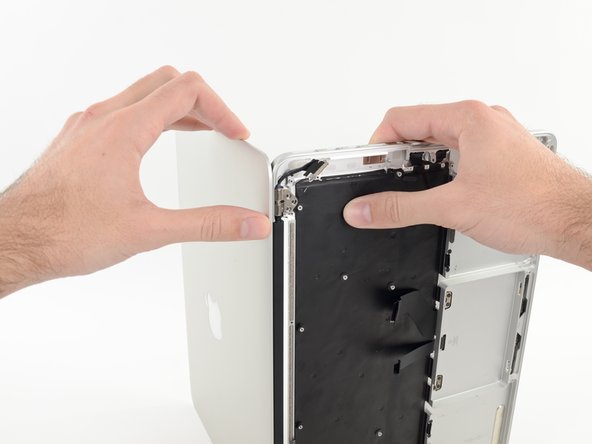 Image 1/3: Gently push forward on the bottom half of the device to detach it from the display assembly.