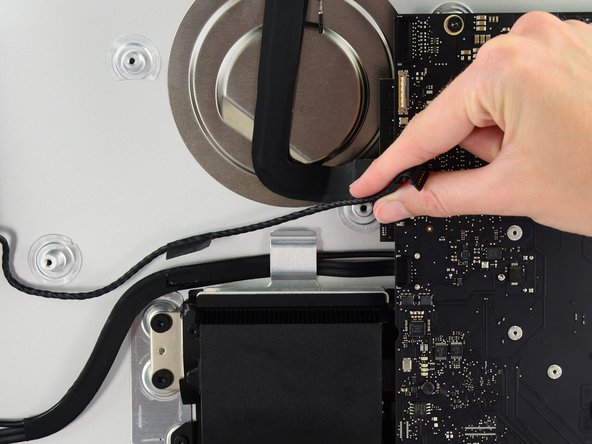 Image 2/3: In a similar fashion, lift the combo SATA data/power cable up out of the retaining clip.