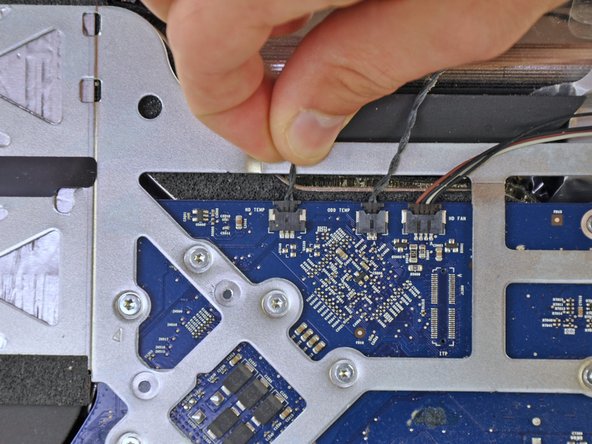 Image 1/1: When removing this connector, it is helpful use your thumbnails to push the ears on either side of the connector toward the top of your iMac.